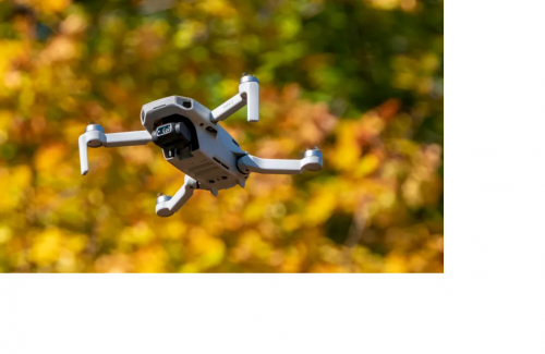 Photo of a drone flying with leaves behind it