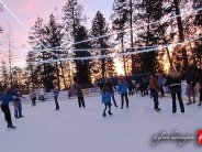 People ice skating at sunset. 