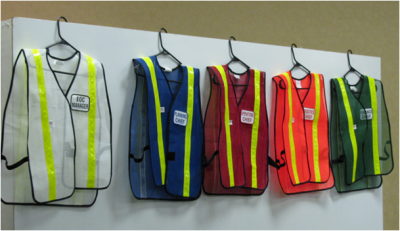 Hi-Vis Safety Vests in a range of colors hang side-by-side on a white back-drop 