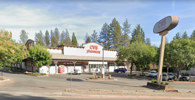 Exterior of building and parking lot with cars parked. 